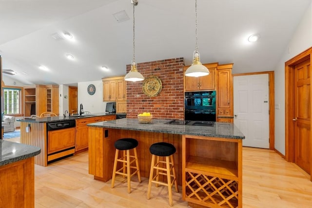 75 Haynes Rd, Sudbury, MA 01776 - kitchen with black appliances, vaulted ceiling, a peninsula, light wood-type flooring, and a center island