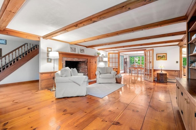 75 Haynes Rd, Sudbury, MA 01776 - living room featuring beam ceiling, light wood-type flooring, stairway, a fireplace, and french doors