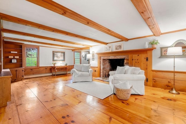 75 Haynes Rd, Sudbury, MA 01776 - living area with beamed ceiling, wainscoting, a brick fireplace, wooden walls, and hardwood / wood-style flooring