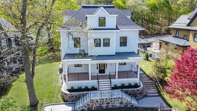 view of front of home featuring a porch, a front lawn, roof with shingles, and stairway