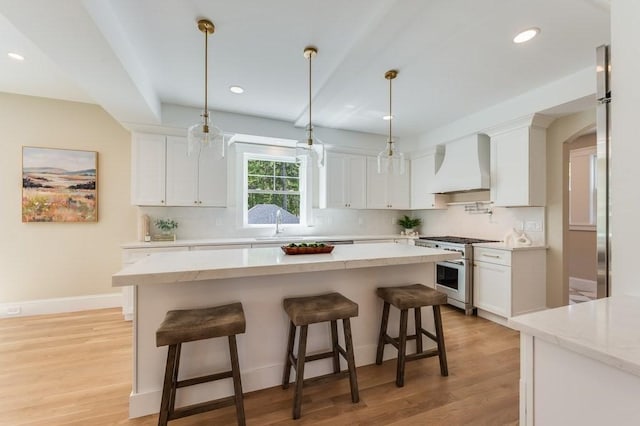 kitchen featuring recessed lighting, custom range hood, and high end stove
