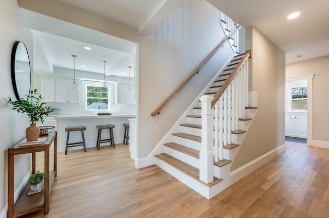 stairs with baseboards, recessed lighting, and wood finished floors