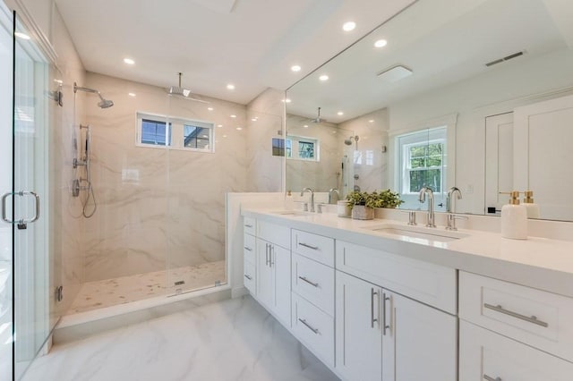 bathroom with visible vents, a sink, and a marble finish shower