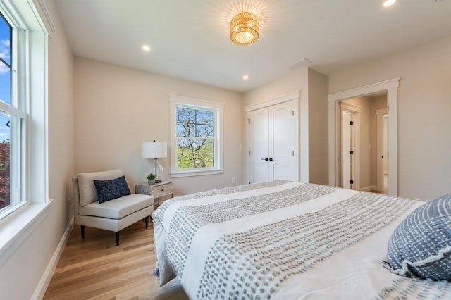 bedroom featuring baseboards, recessed lighting, light wood-style flooring, and a closet