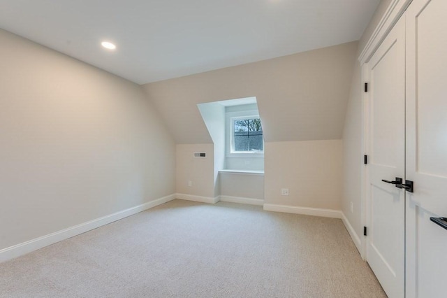 additional living space with recessed lighting, baseboards, light colored carpet, and vaulted ceiling