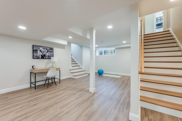 below grade area with recessed lighting, wood finished floors, and stairway