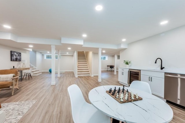 dining room with recessed lighting, light wood-type flooring, stairs, and beverage cooler