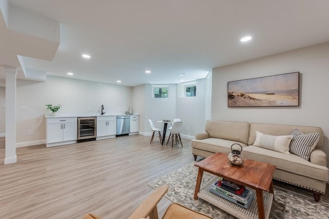 living room featuring indoor wet bar, beverage cooler, recessed lighting, and light wood finished floors