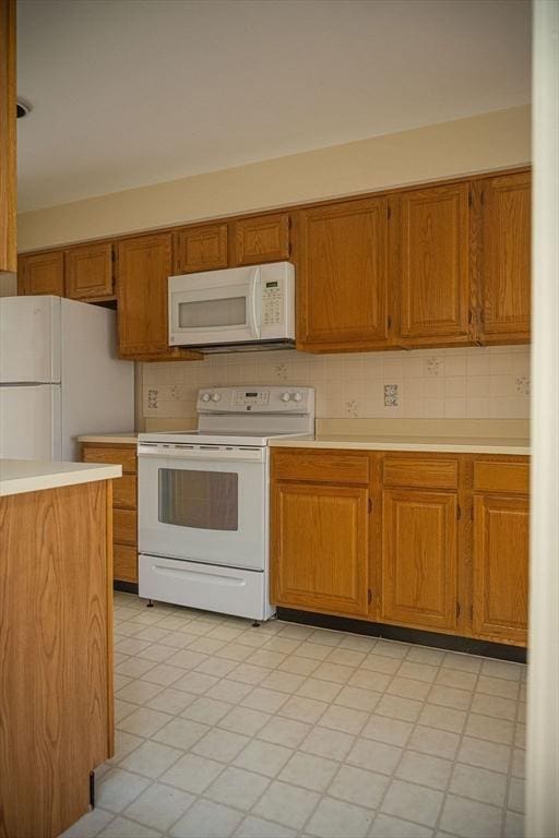 7 Brewster Ln Unit 7, Acton, MA 01720 - kitchen with white appliances, brown cabinets, backsplash, and light countertops