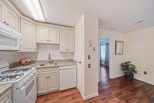 kitchen with white appliances, a sink, decorative backsplash, and wood finished floors