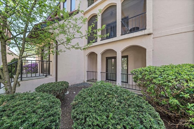 doorway to property with a balcony and stucco siding