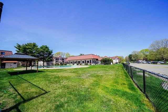 view of yard featuring a gazebo, fence, and a fenced in pool