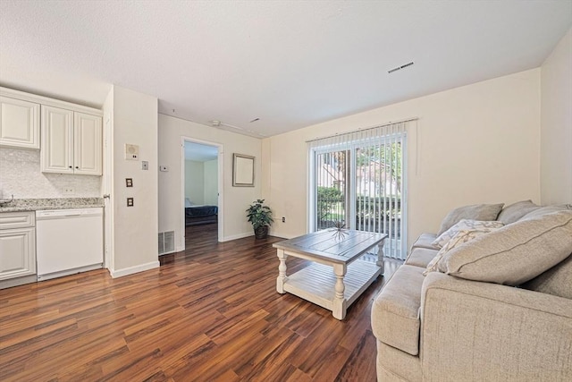living room featuring baseboards, visible vents, and dark wood-style floors