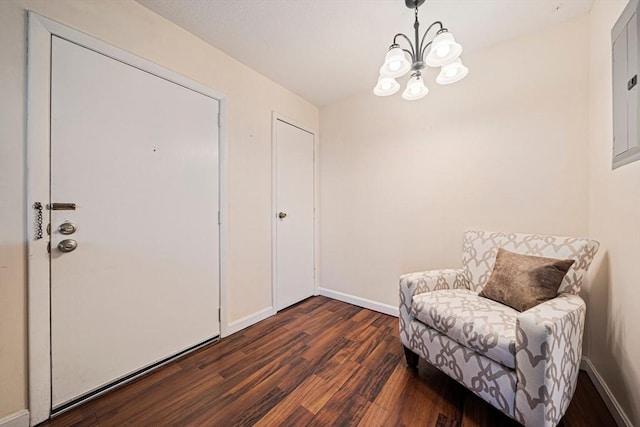 living area featuring an inviting chandelier, baseboards, and dark wood-style floors