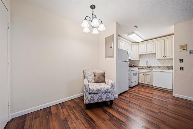 kitchen with light countertops, baseboards, dark wood-style floors, a notable chandelier, and white appliances