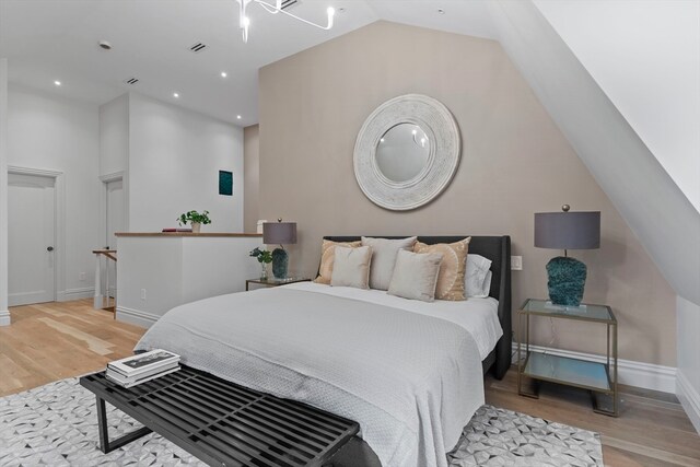 bedroom featuring light hardwood / wood-style floors and lofted ceiling