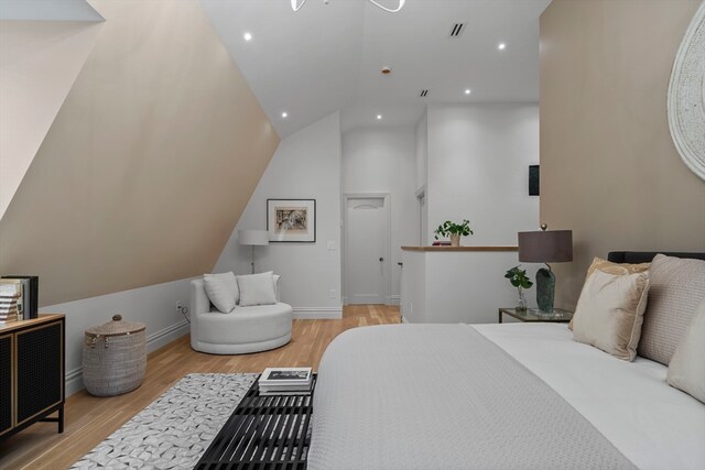 bedroom featuring light hardwood / wood-style flooring and lofted ceiling