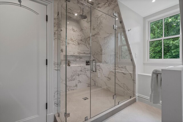 bathroom with tile patterned flooring, a healthy amount of sunlight, and a shower with door