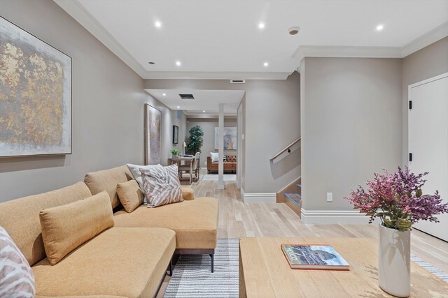 living room featuring light hardwood / wood-style flooring and ornamental molding