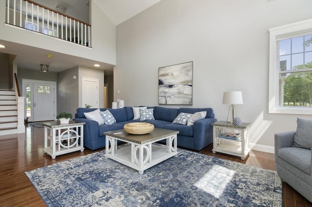 living room featuring dark wood-type flooring, a wealth of natural light, and high vaulted ceiling