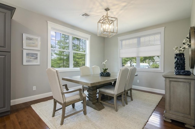 dining space featuring dark hardwood / wood-style flooring and a chandelier