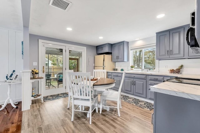 dining area with light wood-type flooring and recessed lighting