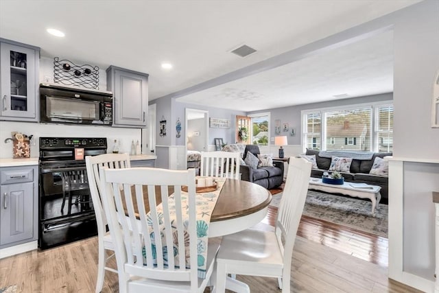 dining space with light wood-type flooring and recessed lighting