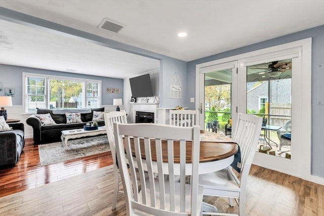 dining area with wood finished floors, a fireplace, and recessed lighting