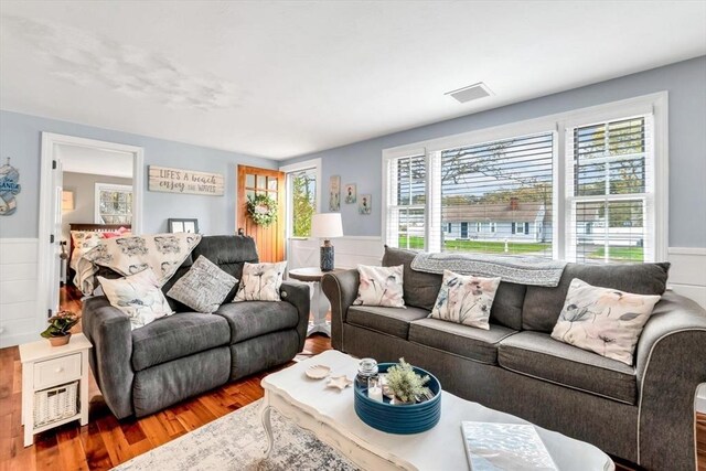 living room with wood finished floors and a wainscoted wall