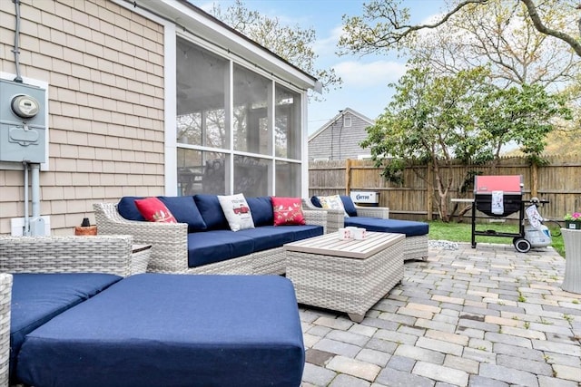 view of patio with fence, an outdoor living space, and a sunroom