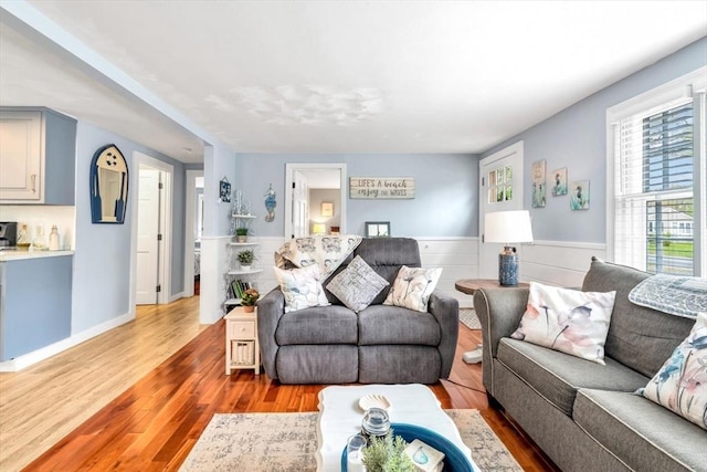 living room with light wood-type flooring and wainscoting