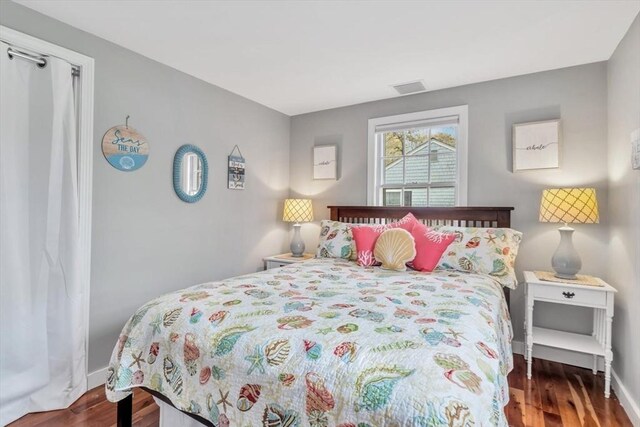 bedroom with wood finished floors and baseboards