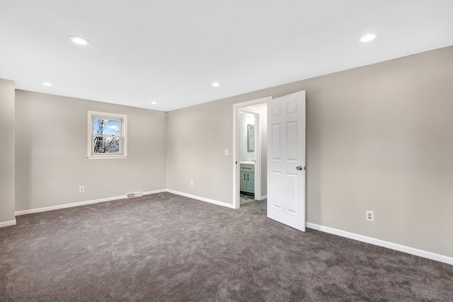 unfurnished room with dark carpet