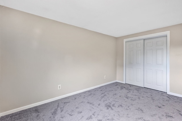 unfurnished bedroom featuring carpet floors and a closet