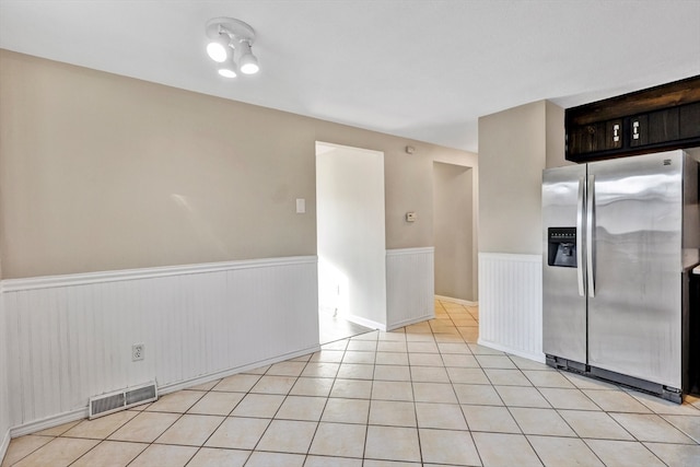 kitchen featuring light tile patterned flooring and stainless steel fridge with ice dispenser