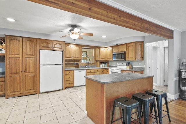 2 Putnam Ln, Auburn, MA 01501 - kitchen featuring white appliances, a breakfast bar area, ceiling fan, a kitchen island, and brown cabinetry