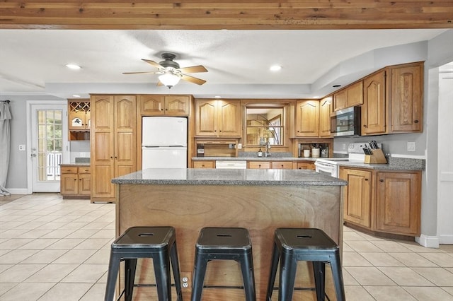 2 Putnam Ln, Auburn, MA 01501 - kitchen featuring white appliances, light tile patterned flooring, a breakfast bar, a ceiling fan, and a kitchen island