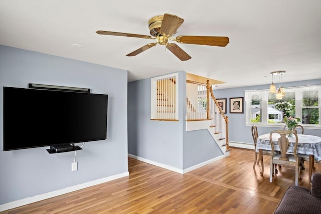 3 Manomet Rd, Woburn, MA 01801 - living area featuring stairway, baseboards, light wood finished floors, ceiling fan, and baseboard heating