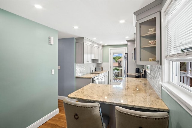 3 Manomet Rd, Woburn, MA 01801 - kitchen featuring tasteful backsplash, gray cabinets, a peninsula, wood finished floors, and light stone countertops