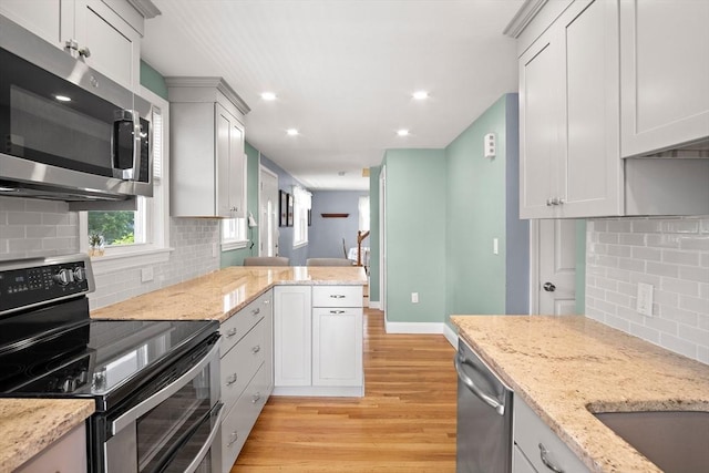3 Manomet Rd, Woburn, MA 01801 - kitchen featuring stainless steel appliances, tasteful backsplash, light wood-type flooring, recessed lighting, and light stone counters