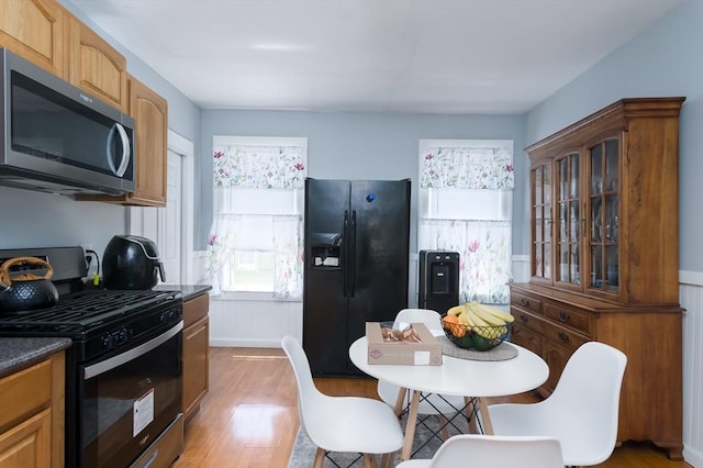30-32 Loxwood St, Worcester, MA 01604 - kitchen with appliances with stainless steel finishes, light wood-style floors, dark countertops, glass insert cabinets, and a desk