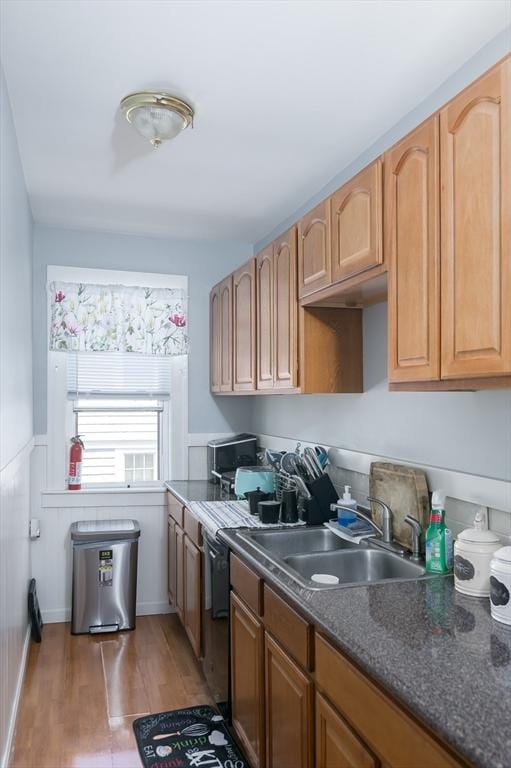 30-32 Loxwood St, Worcester, MA 01604 - kitchen featuring a sink, light wood-style flooring, dark countertops, and a wainscoted wall