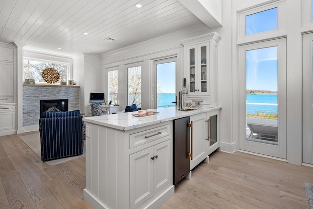 kitchen with wood ceiling, white cabinets, and light wood-style floors