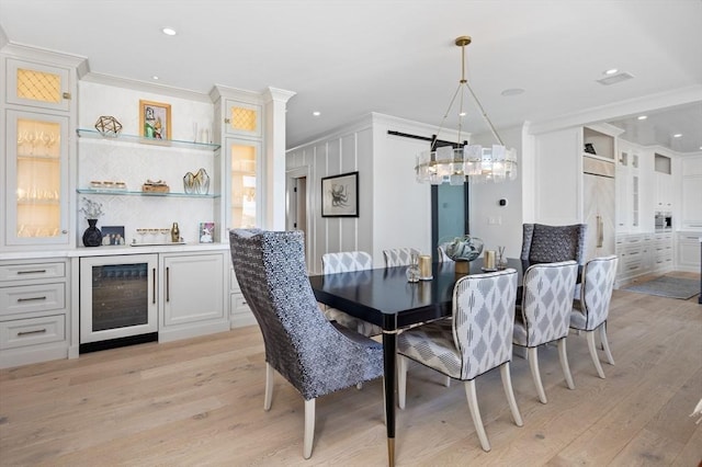 dining space featuring crown molding, beverage cooler, light wood-type flooring, recessed lighting, and a notable chandelier