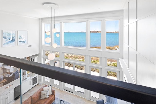 sunroom / solarium featuring visible vents and a water view