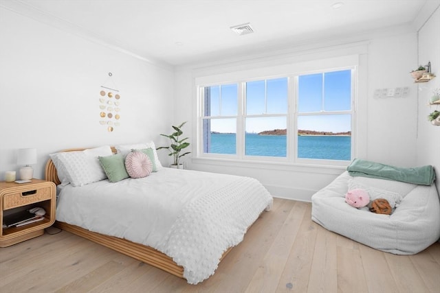 bedroom featuring visible vents, ornamental molding, and hardwood / wood-style floors