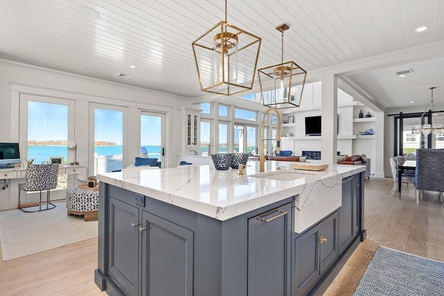 kitchen with crown molding, light wood-style flooring, open floor plan, and gray cabinetry