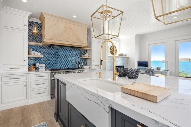 kitchen featuring open shelves, custom exhaust hood, a sink, high end stove, and crown molding