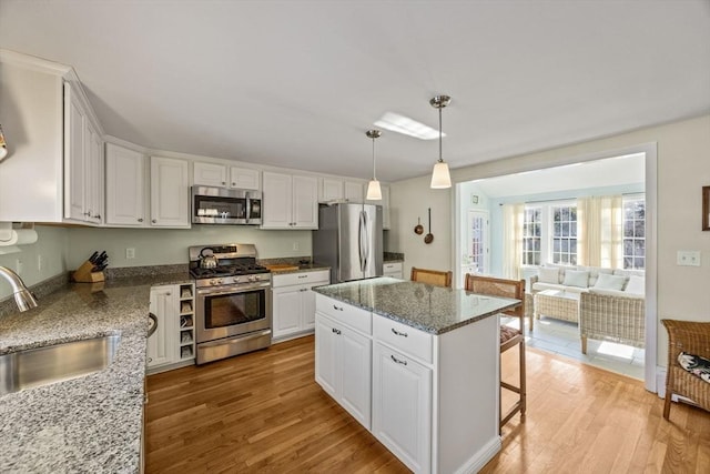 kitchen with white cabinetry, light wood-style flooring, appliances with stainless steel finishes, and a sink