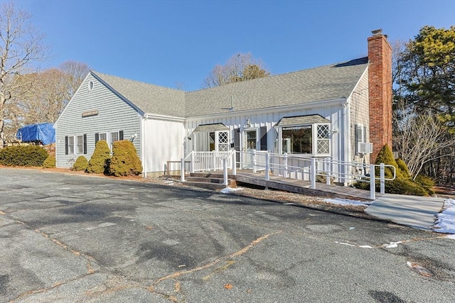 view of front of property with roof with shingles and a chimney